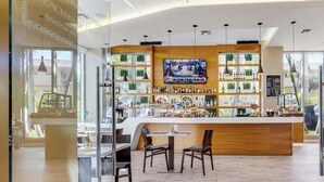 Un espace bar avec un comptoir en bois, des sièges et un écran de télévision.
