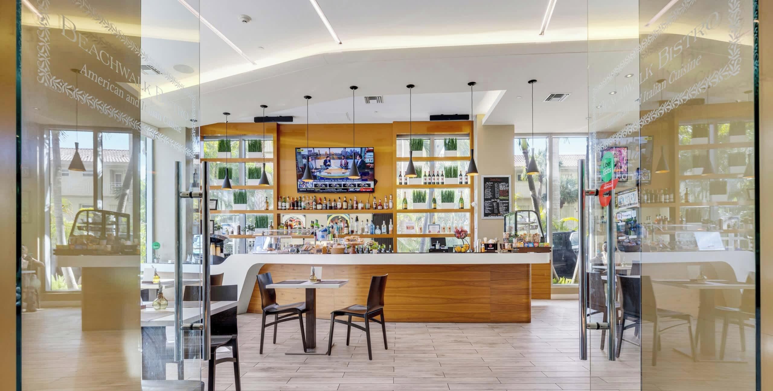A bar area with a TV screen, wooden counter, and seating.