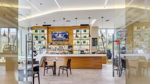 Un espace bar avec un comptoir en bois, des sièges et un écran de télévision.