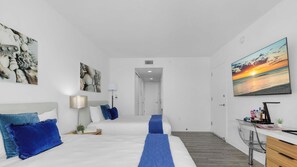 Ein modernes Hotelzimmer mit Bett, Schreibtisch und Blick auf den Sonnenuntergang.