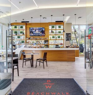 Eine moderne Bar mit Fernseher, Holztresen und Sitzgelegenheiten.