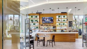 A bar area with a wooden counter, seating, and a TV screen. - Cozy Studio with Private Balcony & Bay View (Hallandale Beach)