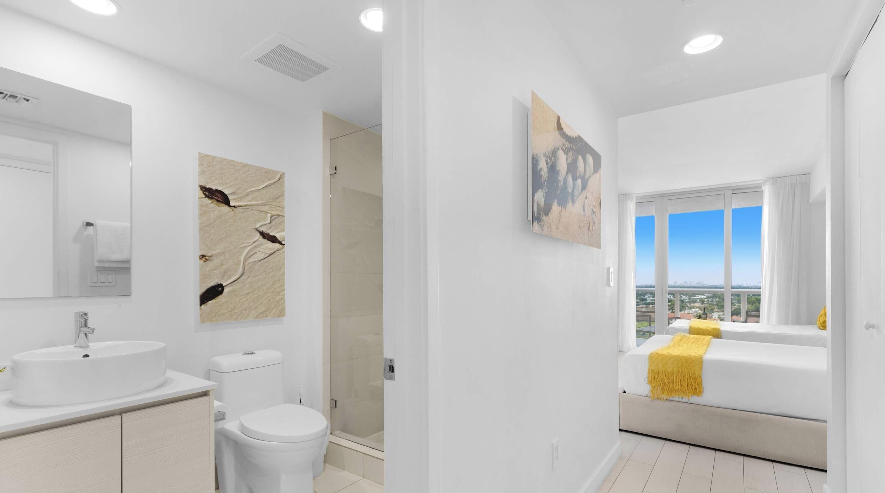 A modern bathroom with a large mirror, a sink, toilet, and a shower.