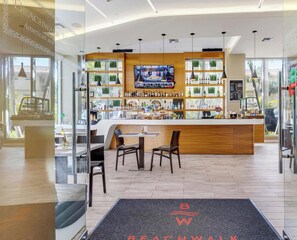 A modern bar area with a TV screen, wooden counter, and seating. - New! 1BR Intracoastal & Marina View, Pool & Beach (Hallandale Beach)