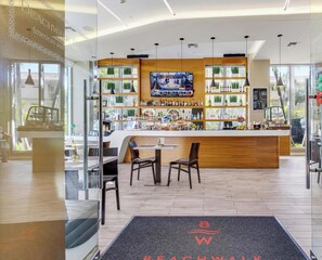 Eine moderne Bar mit Fernseher, Holztresen und Sitzgelegenheiten.
