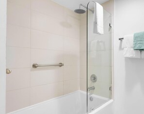 A shower with a glass door, a handrail, and a white towel hanging on the wall. - Sunset Panorama 2BR · Beachwalk High Floor (Hallandale Beach)