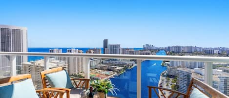 A balcony with a view of a city skyline and a body of water.