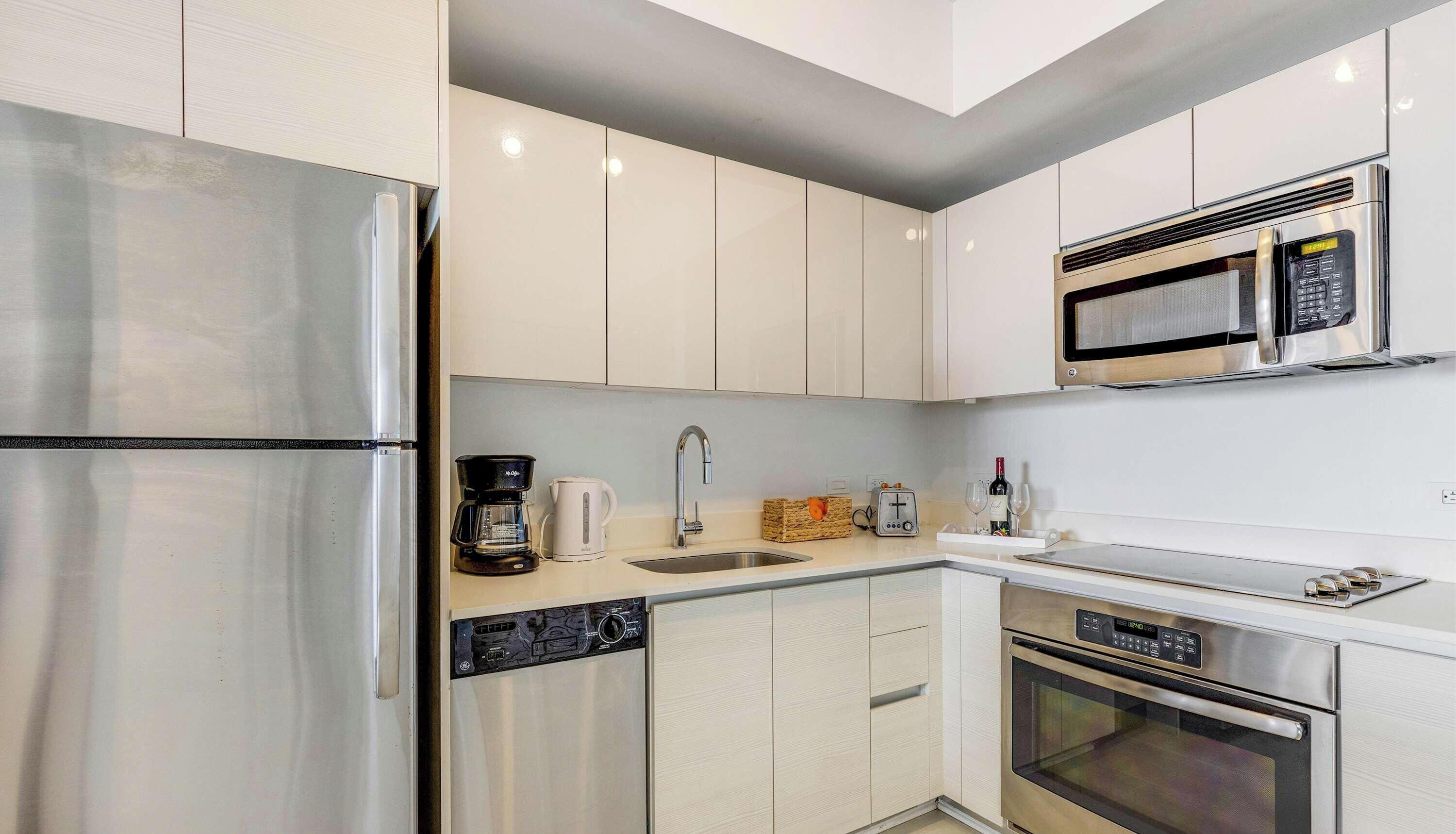 A modern kitchen with stainless steel appliances, a microwave, and a coffee maker.