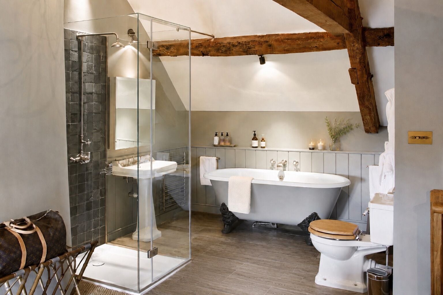 A modern bathroom with a glass-enclosed shower, a freestanding bathtub, and a toilet.