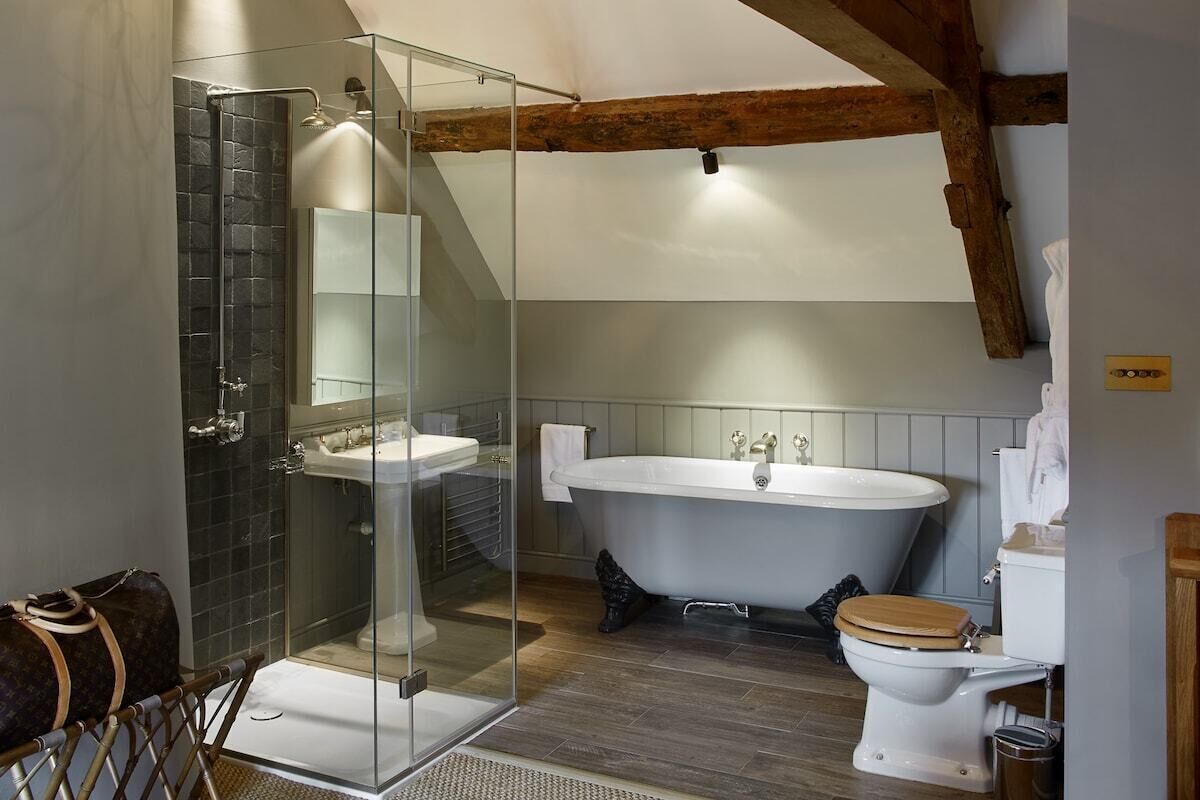 Ein Badezimmer mit Duschkabine, freistehender Badewanne und Toilette.