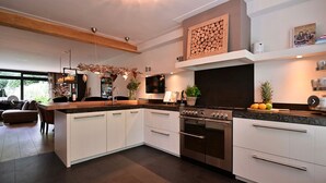 Een moderne keuken met witte kastjes, een ingebouwde oven en een groot kookeiland.
