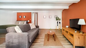 A modern living room with a sofa, TV, and a small table. - City Loft Retreat Near Taksim Square (Istanbul)