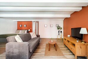 A modern living room with a sofa, TV, and a small table. - City Loft Retreat Near Taksim Square (Istanbul)