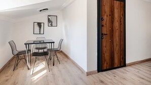 A room with a dining table, chairs, a wooden door, and two framed pictures on the wall. - City Loft Retreat Near Taksim Square (Istanbul)