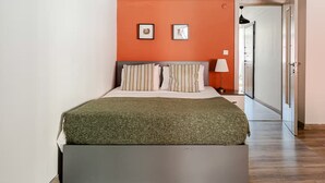 A bedroom with a bed, a nightstand, a lamp, and two framed pictures on the wall. - City Loft Retreat Near Taksim Square (Istanbul)