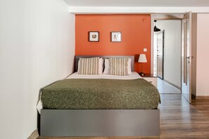 A bedroom with a bed, a nightstand, a lamp, and two framed pictures on the wall. - City Loft Retreat Near Taksim Square (Istanbul)