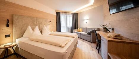 Una habitación de hotel moderna con una cama grande, un escritorio y un espacio para sentarse.