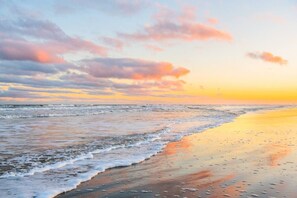 A beach with waves, a sunset, and a clear sky. - No Plana Cabana Close to Beach (Port Aransas)