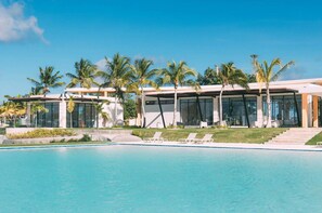 A modern resort with a swimming pool, palm trees, and a clear blue sky. - Villa de lujo totalmente equipada en Vista Cana a minutos del centro (Punta Cana)