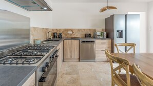 Una cucina moderna con piano cottura a gas, lavastoviglie ed elettrodomestici in acciaio inossidabile.