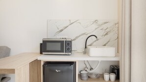A compact kitchenette with a microwave, sink, and built-in refrigerator. - Artemis Studio Apartment in Laganas, Zante with Sea Activities (Laganas)