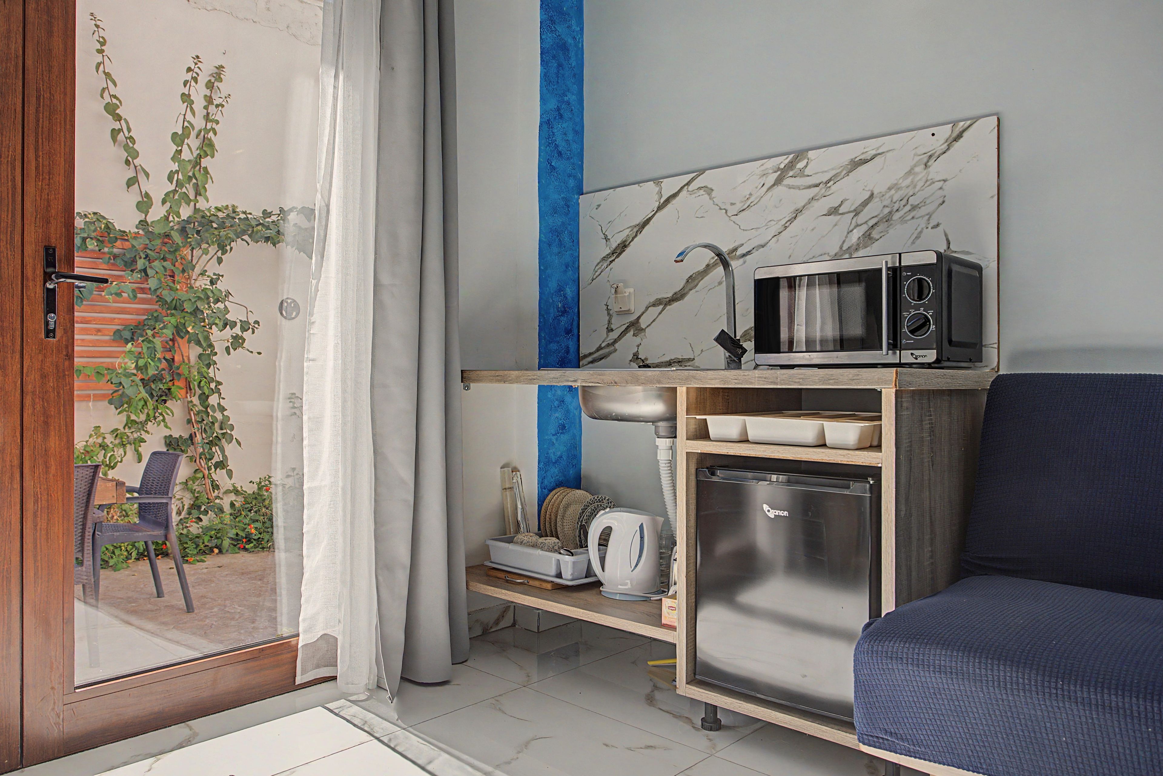 A compact kitchen with a microwave, refrigerator, and a small countertop.