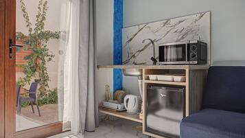 A compact kitchen with a microwave, refrigerator, and a small countertop.