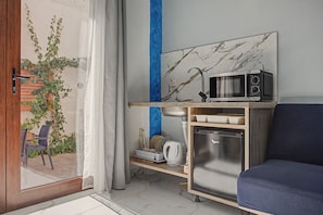 A compact kitchen with a microwave, refrigerator, and a small countertop. - Poseidon Apartment in Laganas, Zante with Scuba Diving and Boat Tours (Laganas)