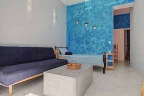 Una sala moderna con un sofá, una mesita y una pared azul de acento.