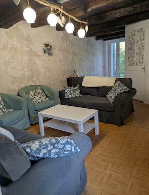 Una sala de estar con dos sofás, una mesa de centro y piso de madera.