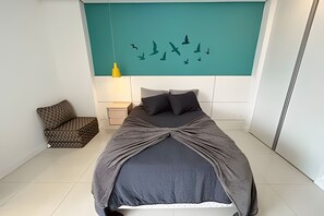 A bedroom with a bed, a nightstand, a lamp, and a chair. - SA Clube XV  Apto CXV1601 (Santos)