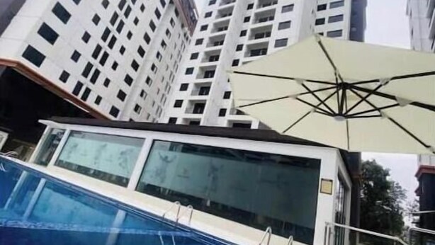 Una piscina con un edificio moderno al fondo.