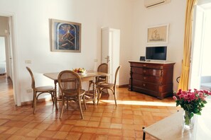 A dining area with a table, chairs, a television, and a dresser. - Villa Angie by My Villa Collection (Positano)