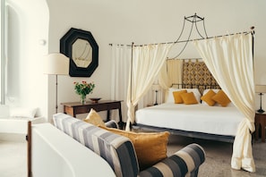Ein Schlafzimmer mit einem Bett, einem Nachttisch, einer Lampe, einem Sessel und einer Wanddekoration.