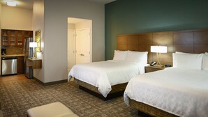 Une chambre d’hôtel avec deux lits, une kitchenette et une salle de bain.