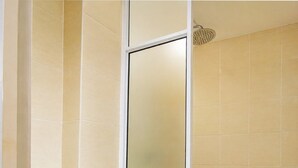 Un inodoro blanco en un baño con azulejos color beige.