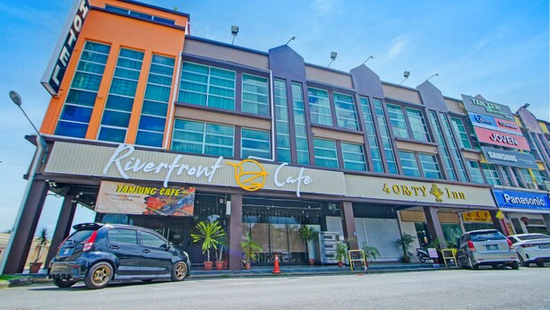 Un edificio de varios pisos con diversos comercios, incluyendo una cafetería y tiendas de electrónica.