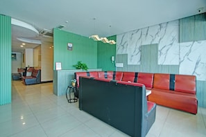 A modern lobby with a red and black sofa, green walls, and marble-patterned decor. - Collection O Near Tanjung Batu Formerly 4orty Inn (Bintulu)