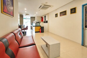 A hotel lobby with a red leather sofa, a reception desk, and framed calligraphy on the walls. - Collection O Near Tanjung Batu Formerly 4orty Inn (Bintulu)