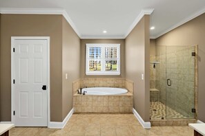 Une salle de bain avec une baignoire, une douche et une fenêtre.