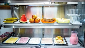 A food display with various fruits, sliced meats, and a pink beverage. - Pousada santa Barbara (Florianópolis)