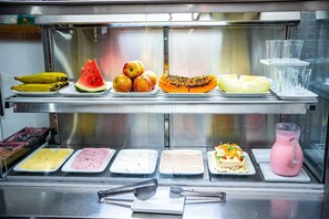 A food display with various fruits, sliced meats, and a pink beverage. - Pousada santa Barbara (Florianópolis)