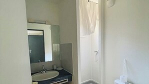 A bathroom with a sink, mirror, toilet, and shower. - Charming renovated studio 2 steps from the sea - Secure residence with all comforts (Sète)