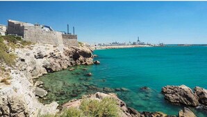 A coastal area with a stone wall and clear turquoise water. - Charming renovated studio 2 steps from the sea - Secure residence with all comforts (Sète)