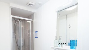 A modern bathroom with a glass-enclosed shower, a white sink, and a toilet. - Bayview Aparthotel by Guestz (Morecambe)