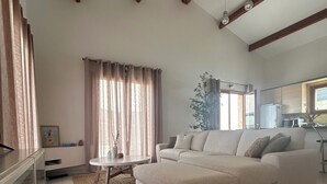 Una sala de estar con un sofá modular, una mesa de centro y un comedor con mesa y sillas.