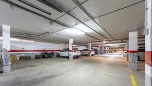 A multi-level parking garage with concrete pillars, marked parking spaces, and a few vehicles. - Nice Apartment Near the Beach With Parking and Wifi (Roquetas de Mar)