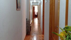 A hallway with a tiled floor, wooden doors, and a metal gate. - Nice Apartment Near the Beach With Parking and Wifi (Roquetas de Mar)
