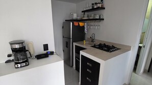 Una cocina moderna con una isla central, estufa integrada y refrigerador.