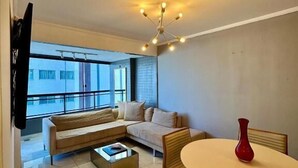 A modern living room with a sofa, coffee table, and dining table. - 504 ocean tower 60m2 sea view 2 quartos (Fortaleza)